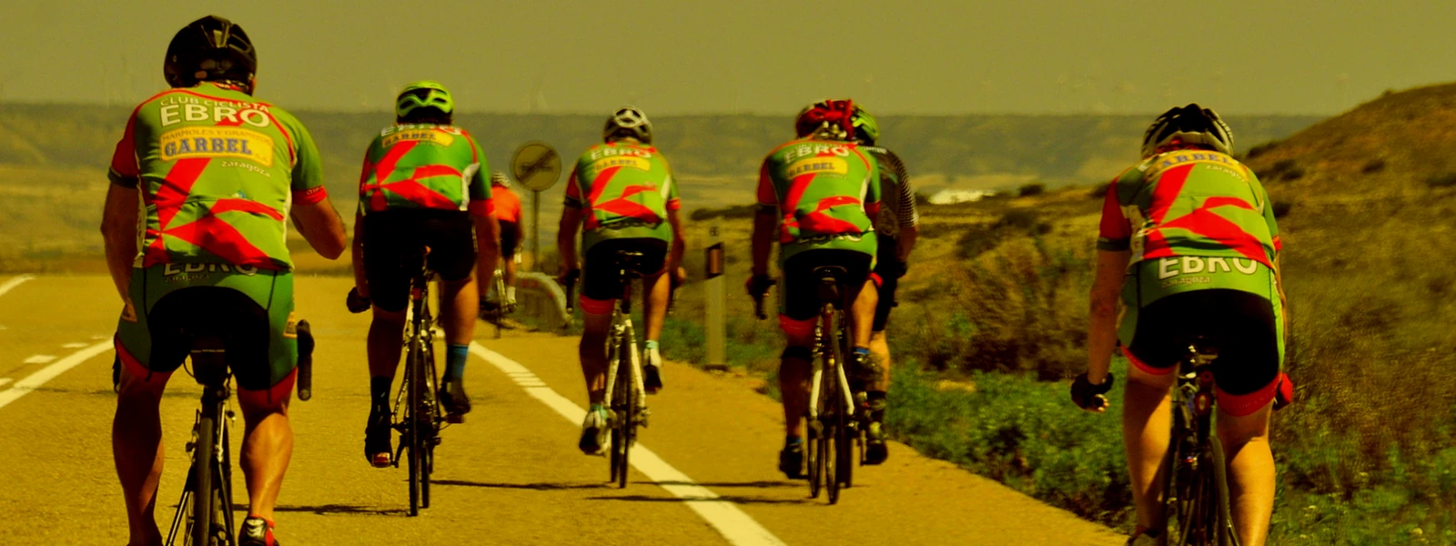pelotón de ciclistas del club por una carretera